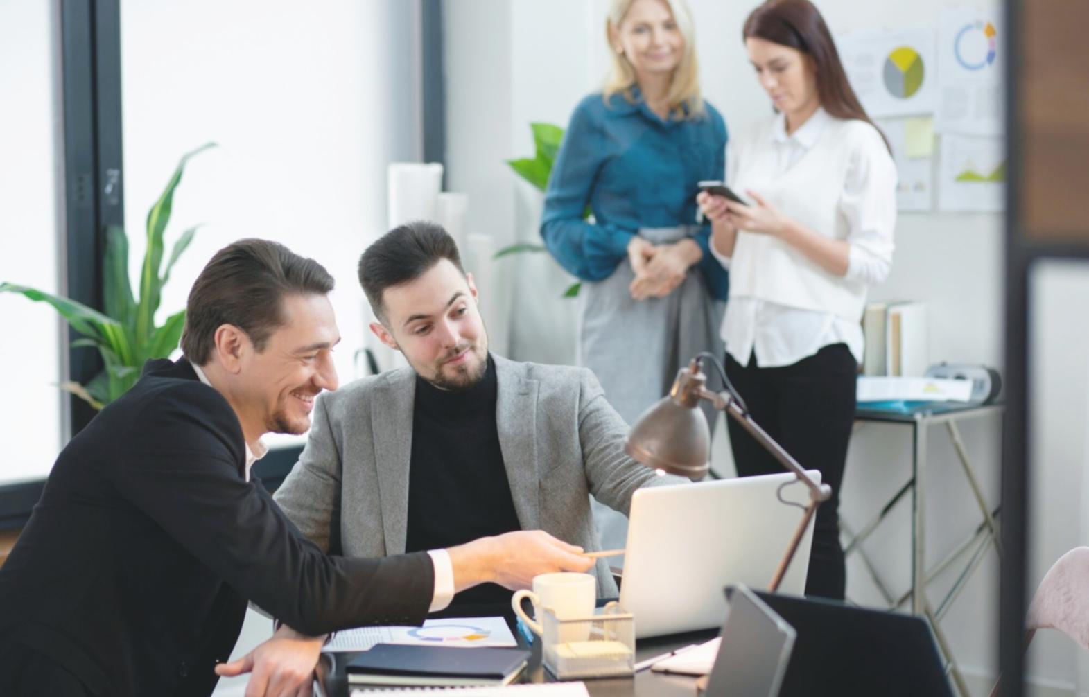 Arbeitsplatz mit Finanzberichten und Laptop in modernem Büro